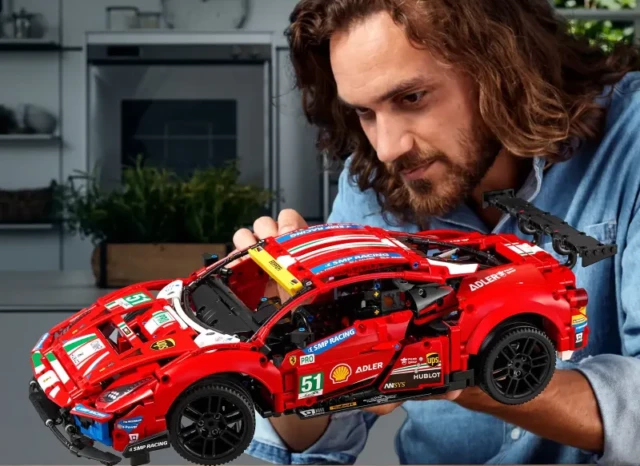 AFOL cieszący się i podziwiający swój złożony model LEGO Ferrari