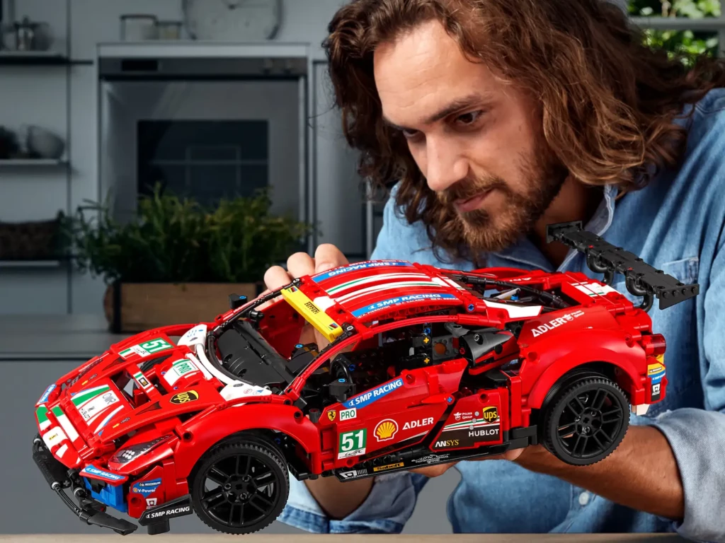 AFOL cieszący się i podziwiający swój złożony model LEGO Ferrari